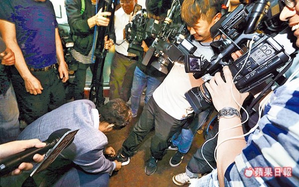 郭台銘彎腰幫記者繫鞋帶。 圖片來源：蘋果日報